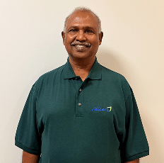 A headshot of a smiling man wearing a dark green polo shirt.