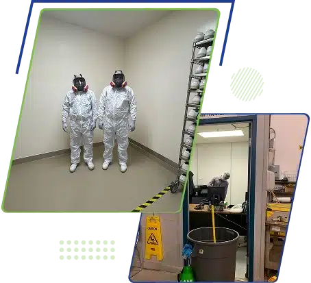 Two workers in full white hazmat suits and respirators standing in an empty room.