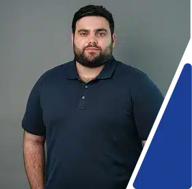 Headshot of a man with a beard wearing a dark blue polo shirt.