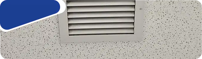 A close-up of a rectangular louvered air vent on a wall.